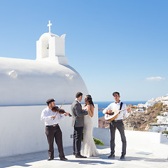 Image showing Bride and groom dansing on wedding ceremony on Santorini island, Greece.