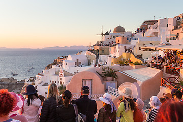 Image showing Indian tourists taking photos of colorful Oia village on Santorini island, Greece.