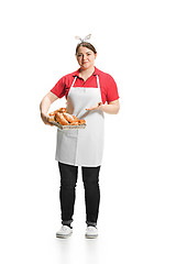 Image showing Portrait of cute smiling woman with pastries in her hands in the studio, isolated on white background