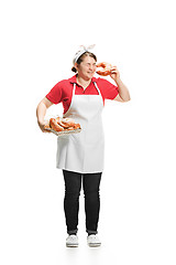 Image showing Portrait of cute smiling woman with pastries in her hands in the studio, isolated on white background