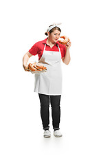 Image showing Portrait of cute smiling woman with pastries in her hands in the studio, isolated on white background