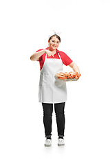 Image showing Portrait of cute smiling woman with pastries in her hands in the studio, isolated on white background