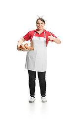 Image showing Portrait of cute smiling woman with pastries in her hands in the studio, isolated on white background