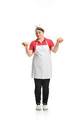 Image showing Portrait of cute smiling woman with pastries in her hands in the studio, isolated on white background