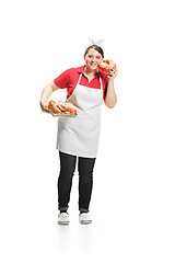 Image showing Portrait of cute smiling woman with pastries in her hands in the studio, isolated on white background