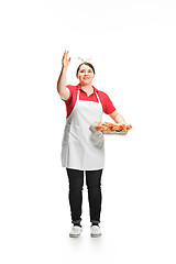 Image showing Portrait of cute smiling woman with pastries in her hands in the studio, isolated on white background