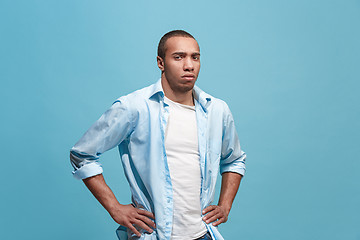 Image showing The serious businessman standing and looking at camera against studio background.