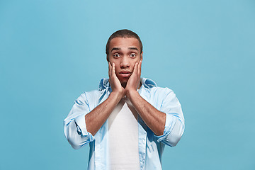 Image showing The young attractive man looking suprised isolated on blue