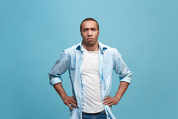 Image showing The serious businessman standing and looking at camera against studio background.