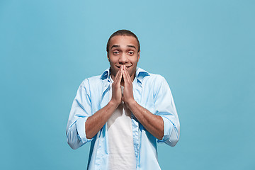 Image showing The young attractive man looking suprised isolated on blue