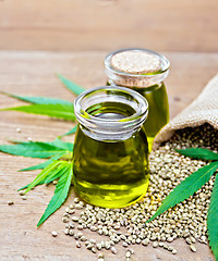 Image showing Oil hemp in two jars with sheet on old board