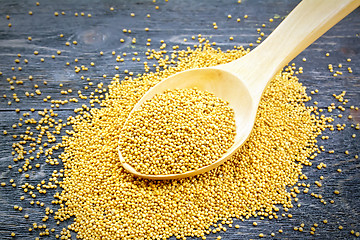 Image showing Mustard seeds in wooden spoon on black board