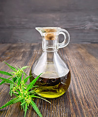 Image showing Oil hemp in glass decanter on dark board