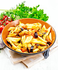 Image showing Pasta penne with eggplant and tomatoes on light board