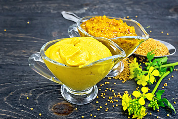 Image showing Sauce mustard in two sauceboats with flower on black board