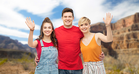 Image showing happy friends hugging over grand canyon