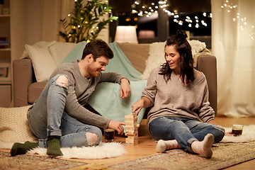 Image showing happy couple playing block-stacking game at home