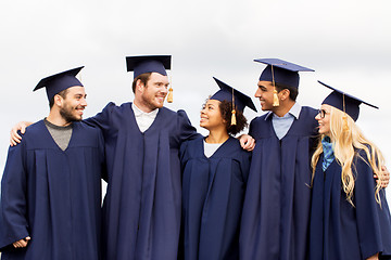 Image showing happy students or bachelors in mortar boards