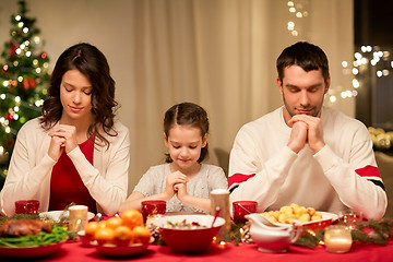 Image showing family praying before meal at christmas dinner