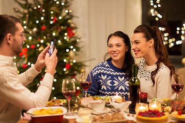 Image showing happy friends photographing at christmas dinner