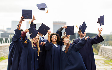 Image showing happy graduates or students throwing mortar boards