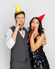 Image showing happy couple with party blowers having fun