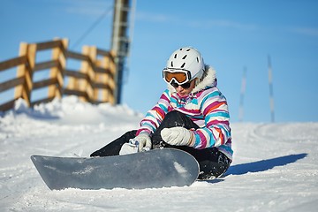 Image showing Snowboarder sitting in the snlow