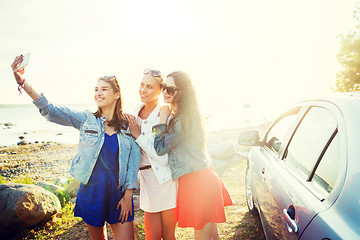 Image showing happy women taking selfie near car at seaside