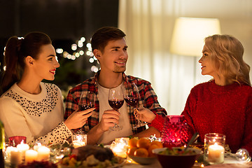 Image showing happy friends drinking red wine at christmas party