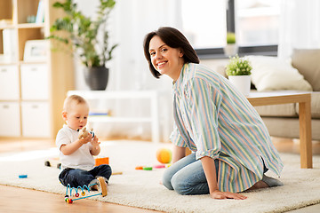 Image showing happy mother with little baby son playing at home