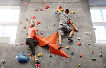 Image showing man and woman climbing a wall at indoor gym