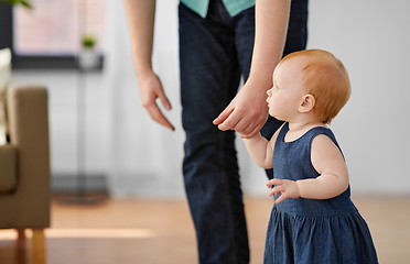 Image showing baby girl walking with father help at home