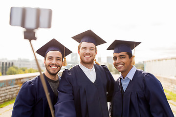 Image showing happy male students taking picture by selfie stick