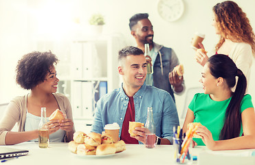 Image showing happy friends or team eating at office party