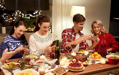 Image showing friends with smartphones having christmas dinner