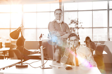 Image showing Young businessman helping his colleague at the work