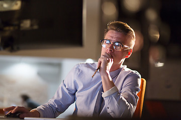 Image showing man working on computer in dark office