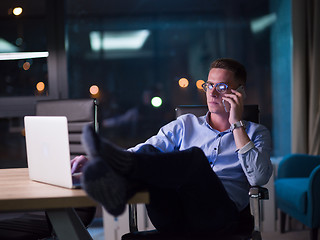 Image showing businessman using mobile phone in dark office