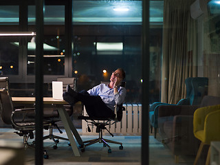 Image showing businessman using mobile phone in dark office