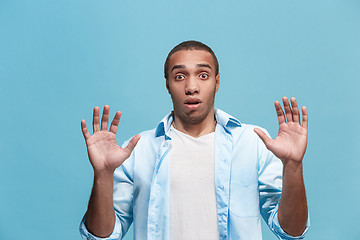 Image showing The young attractive man looking suprised isolated on blue