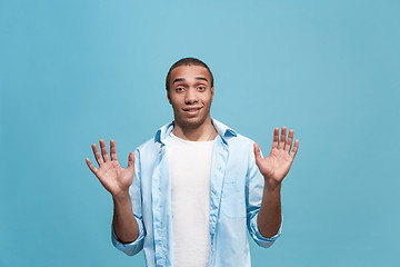 Image showing The young attractive man looking suprised isolated on blue