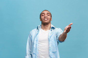 Image showing The happy business man standing and smiling against blue background.