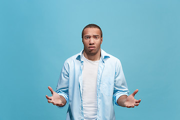 Image showing Afro man looking suprised and bewildered isolated on blue