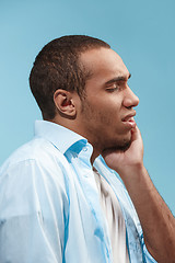 Image showing Sad Afro-American man is having toothache. against blue background