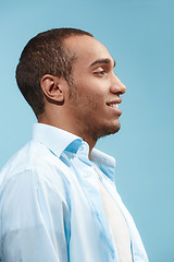 Image showing The happy businessman standing and smiling against blue background.