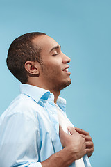 Image showing The happy businessman standing and smiling against blue background.