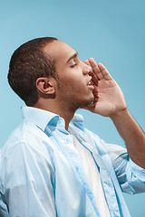 Image showing Happy Afro-American man is shouting against blue background