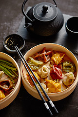 Image showing Oriental traditional chinese dumplings served in the wooden steamer