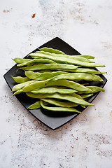 Image showing Black ceramic plate with fresh green bean pods