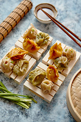 Image showing Delicious mixed kinds of chinese dumplings served on wooden stands